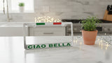 License plate frame with 'CIAO BELLA' text on a kitchen counter.