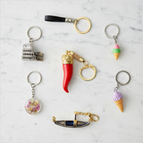 Red keychain with gold crown and ring on a white background