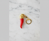 Red keychain with gold accents on a white background